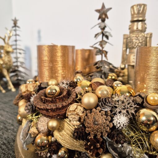 Goldener Adventskranz mit großen Kerzentellern.