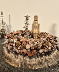 Hübsche Weihnachtsdeko mit Kerzen, Tannenzapfen, Baumkugeln und Zierteilen auf einem dekorativen Untergrund für festliche Stimmung.