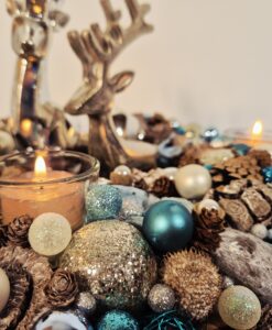 Weihnachtliche Dekoration mit Kerzen, Tannenzapfen, Christbaumschmuck und silbernen Elementen für festliche Stimmung. Ideal für gemütliche Weihnachts- oder Winterdekorationen.