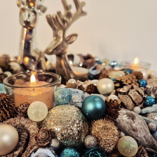 Weihnachtliche Dekoration mit Kerzen, Tannenzapfen, Christbaumschmuck und silbernen Elementen für festliche Stimmung. Ideal für gemütliche Weihnachts- oder Winterdekorationen.